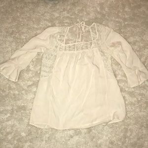 Cream colored blouse with lace and ties in back